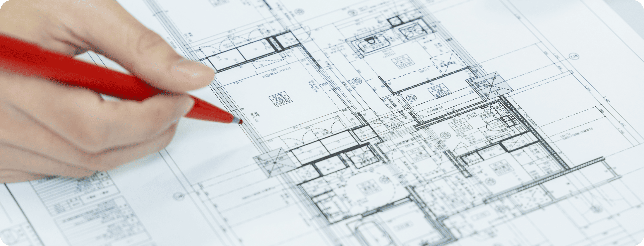 現場で図面を持った管理者が状況を確認しているシーン